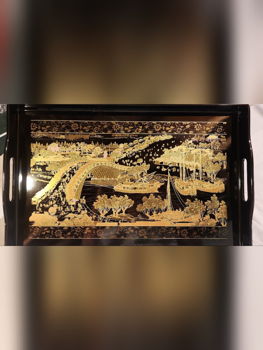 gold lacquered serving tray featuring a detailed Chinoiserie scene, likely depic